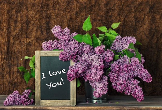 Lila Blumen und Tafel mit Beispieltext Ich liebe dich!