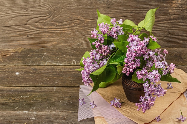 Lila Blumenstrauß mit grünen Blättern in einer Keramikvase Naturobjekt für die Gestaltung