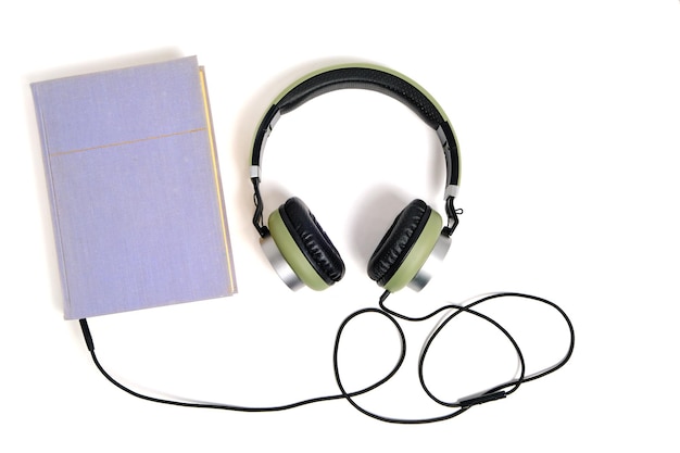 Lila Buch und Kopfhörer auf weißem Hintergrund. Hörbücher online anhören.
