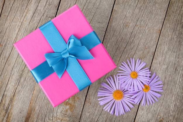 Lila Geschenkbox und Gerbera-Blumen