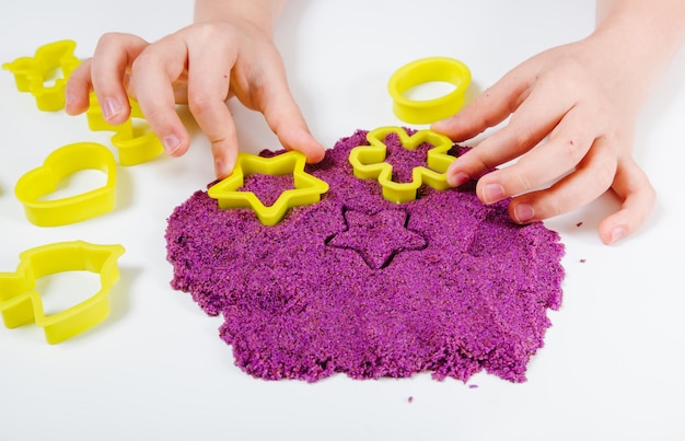 Lila kinetische Sand-Plastikformen für Sand. Kinder formen und spielen mit Sand