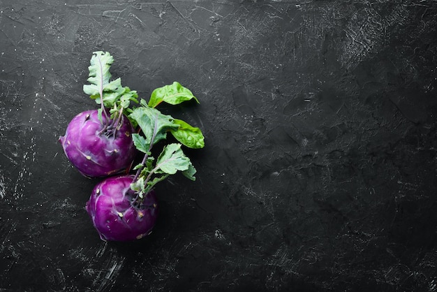 Lila Kohlrabi-Kohl auf einem schwarzen Steinhintergrund Ansicht von oben Freier Platz für Ihren Text