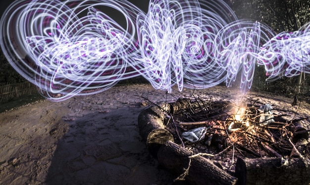 Foto lila lichtspur auf einer feuergrube im wald