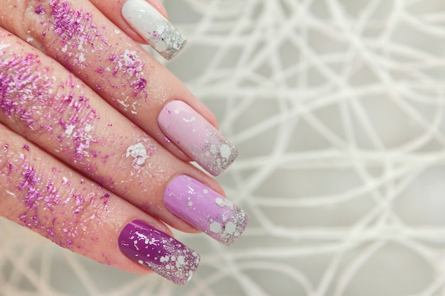 Lila mehrfarbiges Nageldesign mit Glitzer