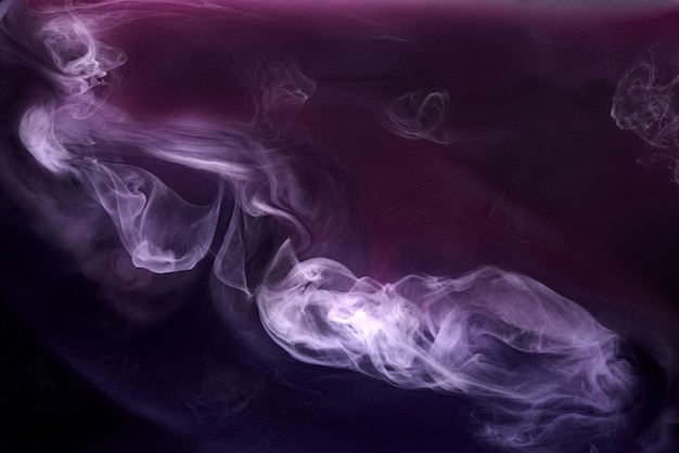 Lila Rauch auf schwarzem Tintenhintergrund, bunter Nebel, abstraktes wirbelndes lila Ozeanmeer, Acrylfarbenpigment unter Wasser