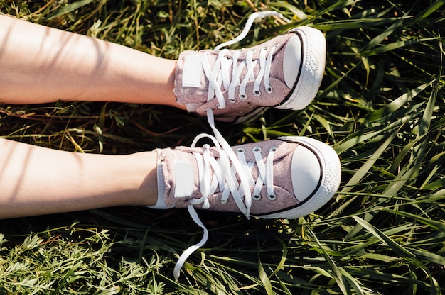 Foto lila turnschuhe auf mädchenbeinen im gras