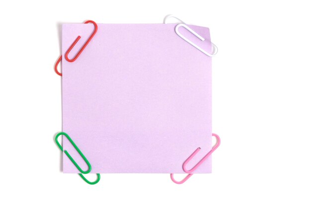 Foto lilafarbener papieraufkleber für schriftliche notizen und büroklammern auf weißem hintergrund