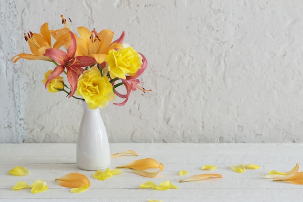 Lilien und Rosen in der weißen Vase auf weißem Hintergrund