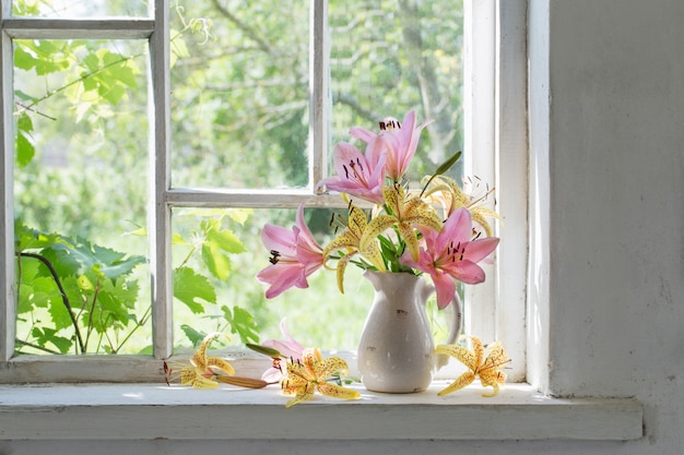 Lilienstrauß auf einem Fensterbrett an einem sonnigen Tag