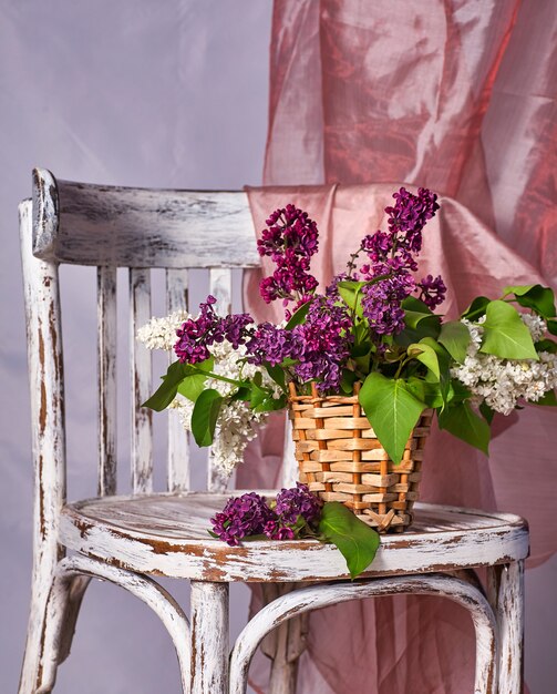 Lillac Blumenstrauß in der Vase auf Vintage Holzstuhl