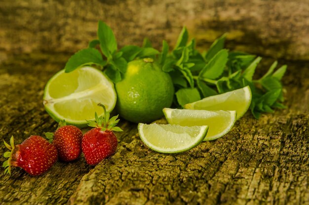 Lima limón y menta Jugosas frutas cítricas maduras en una mesa de madera antigua Ingredientes para cóctel