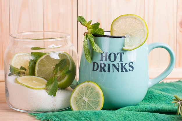Foto lima y menta con azúcar en un frasco de vidrio tintura para té verde fragante bebida saludable caliente en una taza