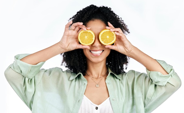 Foto limão cítrico e olhos de mulher com moda para bem-estar orgânico isolado em fundo branco de estúdio dieta de frutas e jovem feliz ou animado com energia saudável de vitamina c louca e desintoxicação