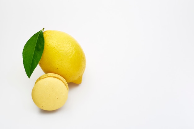 Limão de frutas com macarons amarelos em um branco