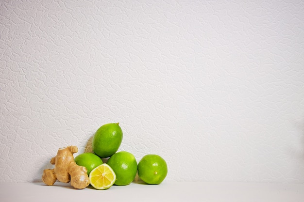 Limão e gengibre em um fundo branco fazendo chá quente e limonada refrescante