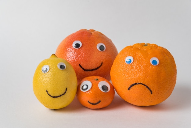 Limão e laranja tangerina grapefruit com caras engraçadas e olhos googly. conceito de família vegetariana.