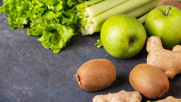 Limão, kiwi, aipo e gengibre sobre a mesa escura. Comida saudável