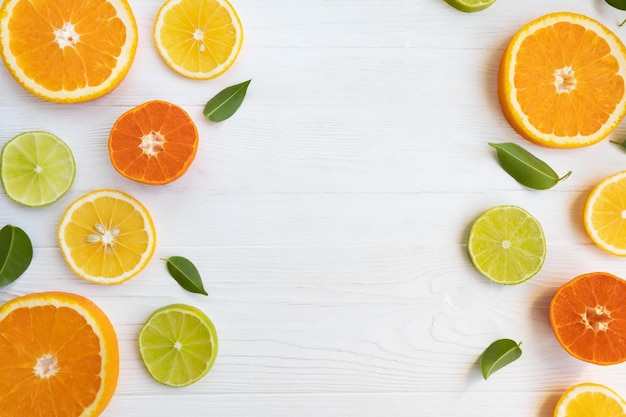 Limão limão laranja e toranja e tangerinas cortadas em círculos em um fundo branco com espaço para texto