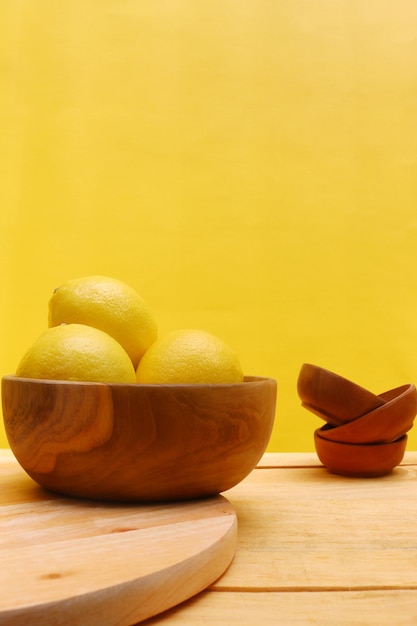 limão na mesa de madeira e fundo amarelo