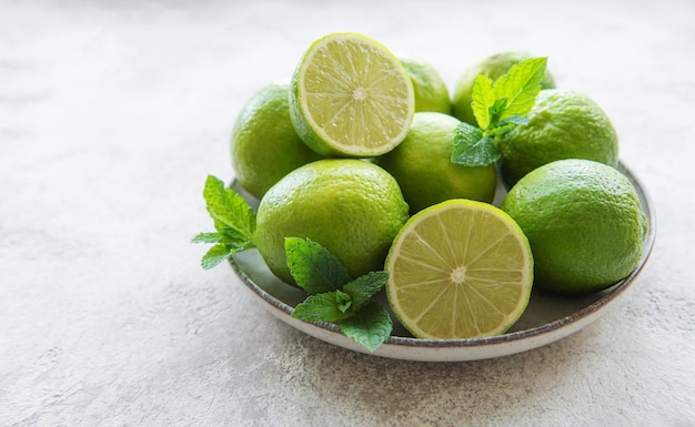 Limas verdes com folhas de hortelã fresca no prato