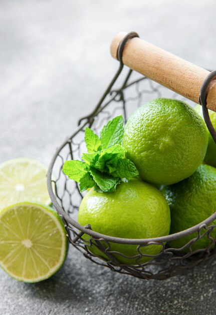 Limas verdes con hojas de menta fresca en cesta