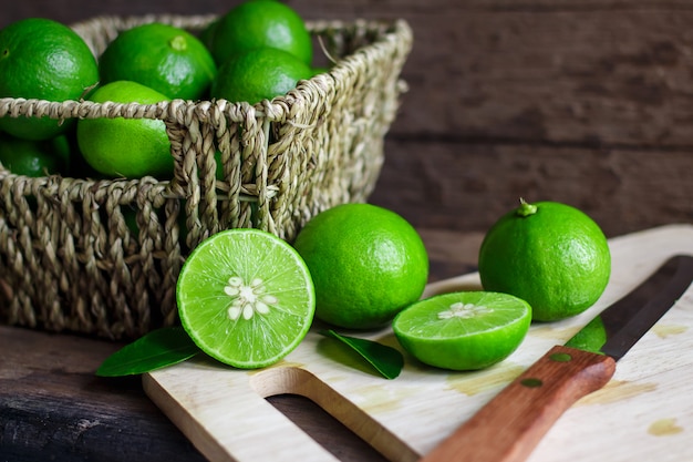 Limes frescos na cesta em um fundo de madeira