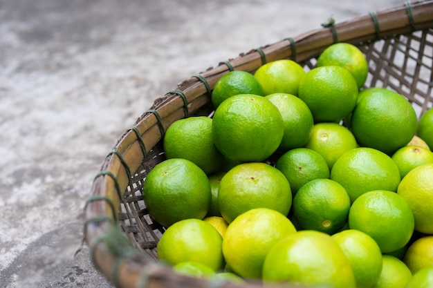 Limes verdes frescos em cesta de madeira para vender no mercado