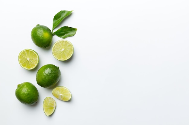 Limettenfrüchte mit grünem Blatt und in halbe Scheibe geschnitten, isoliert auf weißem Hintergrund Draufsicht Flach mit Kopierbereich