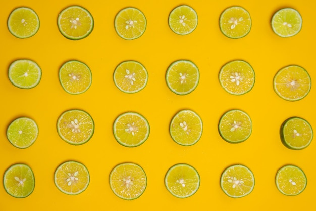 Limettenscheibe auf gelbem Hintergrund Niedliche Tapete für ein gesundes Sommergetränk