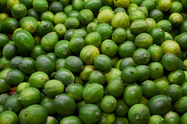 Limões verdes colocados em uma prateleira para venda em um mercado