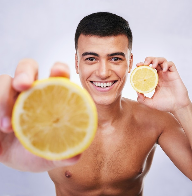 Limón de belleza y oferta con retrato de hombre en estudio para desintoxicación de salud y cosméticos Nutrición de vitamina c y verano con cara de persona y fruta sobre fondo blanco para cuidado personal y cuidado de la piel