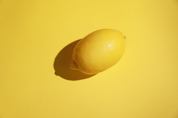 Foto limón entero sobre un fondo de color amarillo brillante
