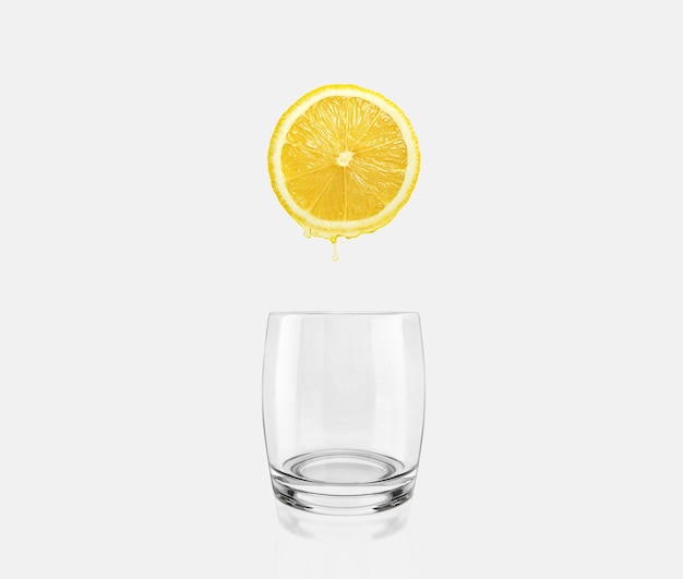 Limón fresco y rodajas goteando sobre el concepto de atención médica de vidrio vacío