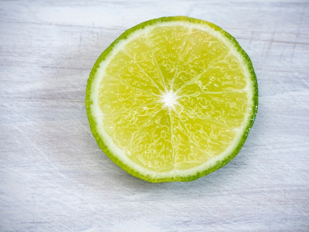 Limón con hojas sobre fondo blanco de madera