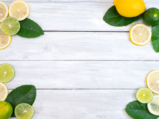 Limón con hojas sobre fondo blanco de madera