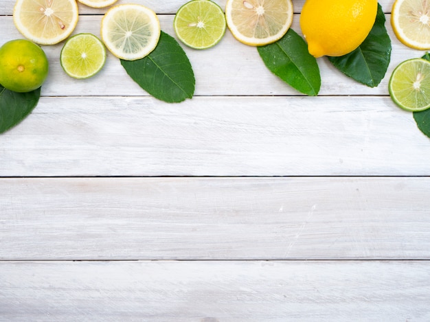 Limón con hojas sobre fondo blanco de madera