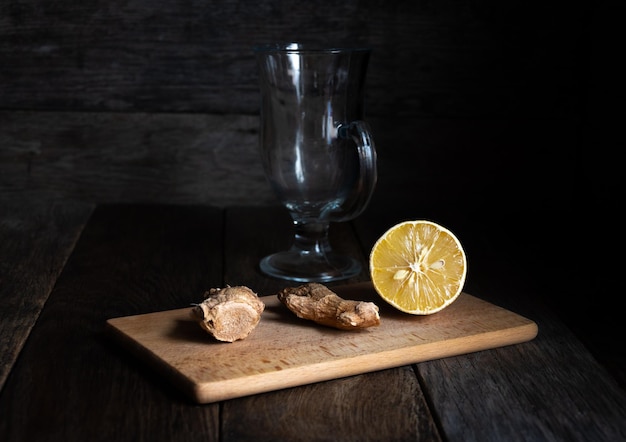 Limón y jengibre en una tabla de cortar para hacer té medicinal.