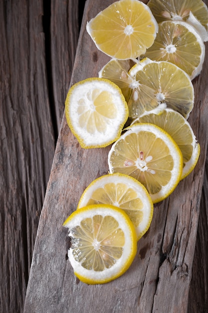 Limón y lado de limón en el oscuro fondo de textura de madera vintage