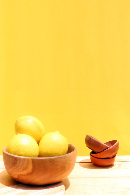 limón en la mesa de madera y fondo amarillo