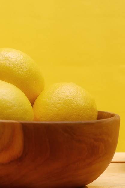 limón en la mesa de madera y fondo amarillo