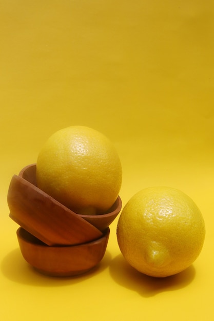 limón en la mesa de madera y fondo amarillo