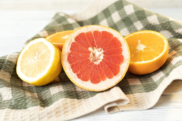 Foto limón, naranja y pomelo en la mesa, jugosas frutas vitamínicas