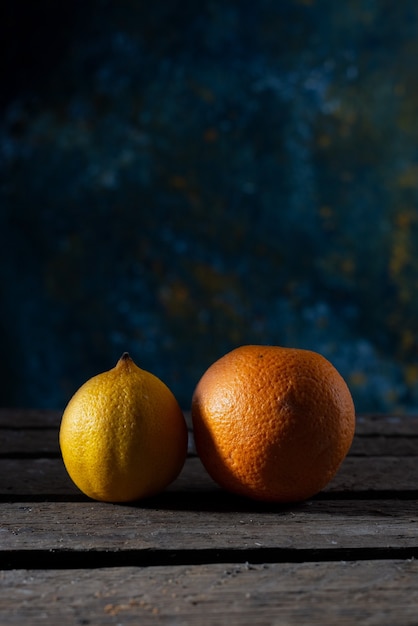 Limón y naranja sobre una mesa de madera con un fondo rústico