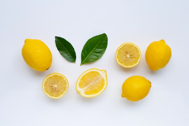 Limón y rebanadas con las hojas aisladas en blanco.