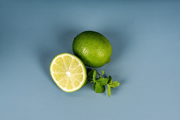 Limón verde y menta sobre un fondo azul y verde