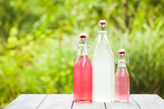 Limonada de bayas en las botellas sobre la mesa al aire libre