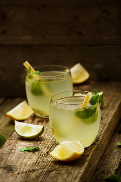 Limonada caseira em dois copos com canudos na mesa de madeira velha