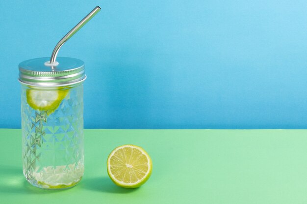 Limonada caseira em vidro em fundo verde-azul com espaço de cópia