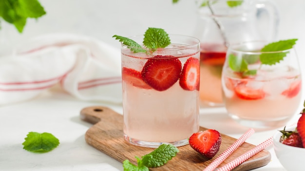 Limonada caseira refrescante de morango na jarra e no copo na placa de madeira