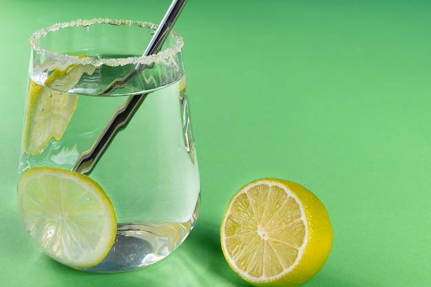 Foto limonada caseira sobre fundo verde com limão e espaço de cópia